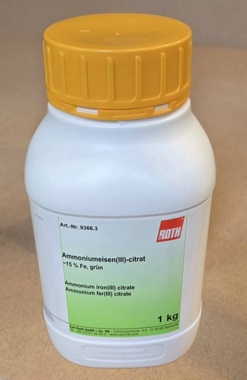 En hvid plastbeholder med gult låg mærket Ammoniumjern(3)citrat, grøn (1 kg).