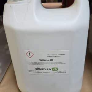 En hvid 5L Saltsyre 4M-beholder i plast med faresymbol og dansk tekst står på en beige overflade.