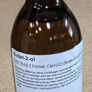 En 200 ml brun glasflaske med sort hætte, mærket Butan-2-ol og med danske advarsler og produktinformation.