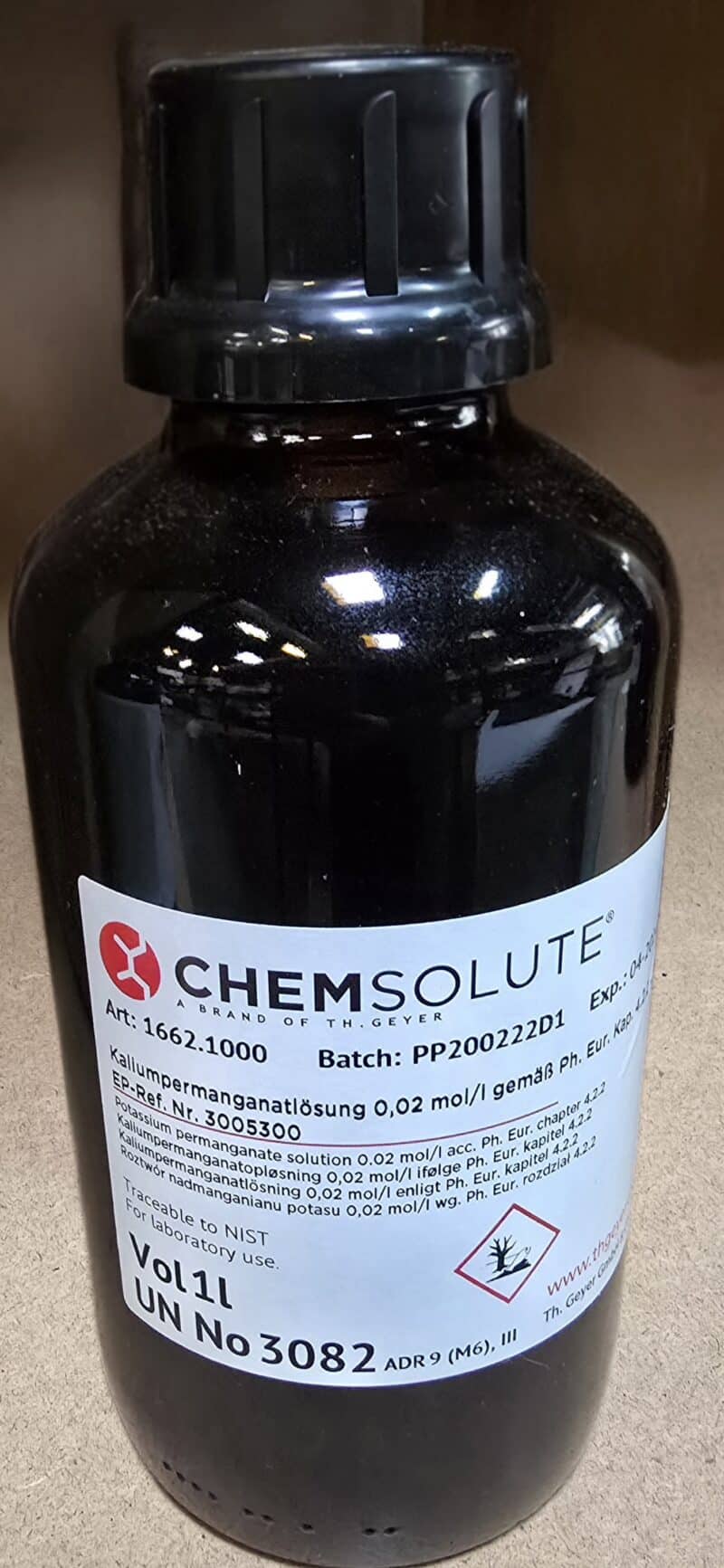 En brun flaske mærket "CHEMSOLUTE", der indeholder Kaliumpermanganat 0,02 M (1 L) med produkt-, batch- og sikkerhedsoplysninger på etiketten.