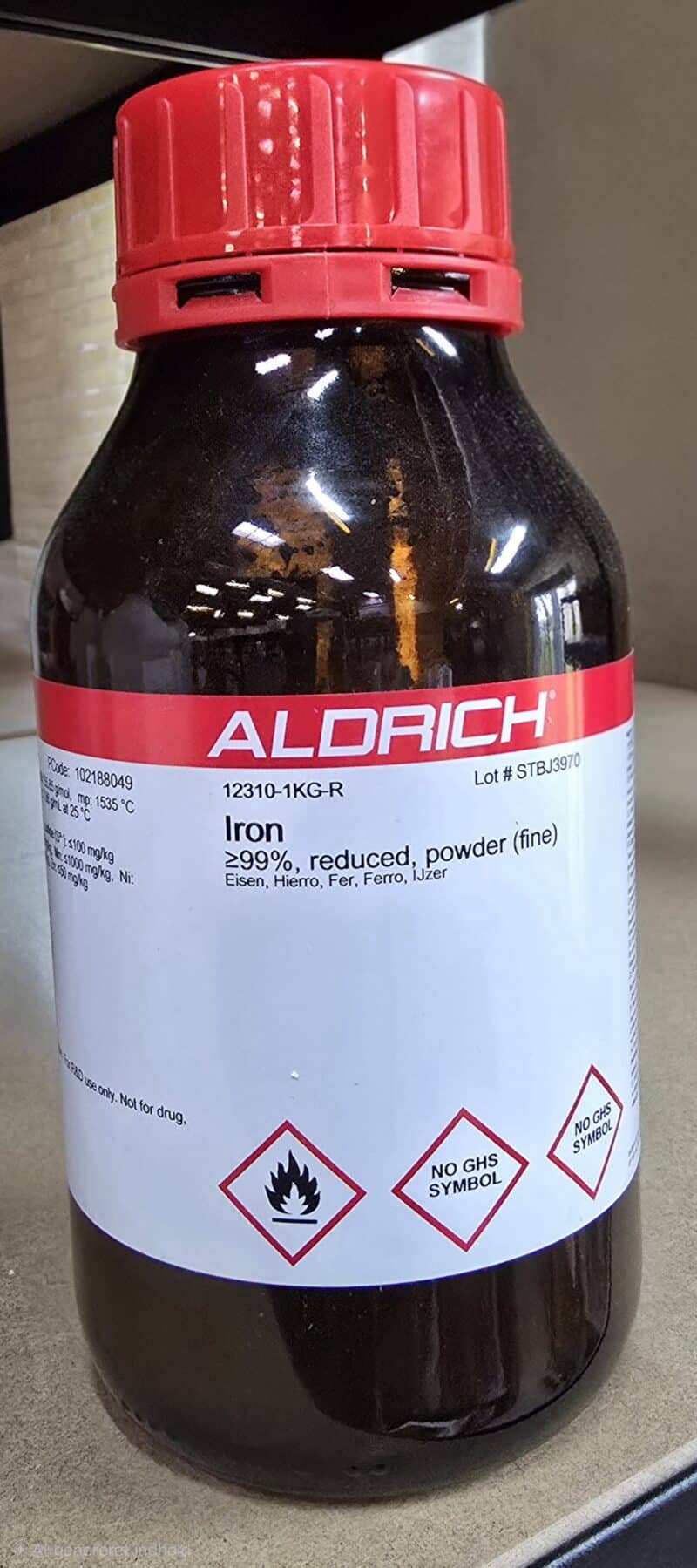 En 1 kg beholder med Jern(II)chlorid tetrahydrat, p.a. med faresymboler, fra Aldrich.