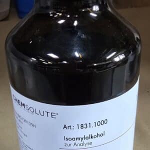 En 1-liters mørk glasflaske mærket Isoamylalkohol med faresymboler står på en laboratorieoverflade.