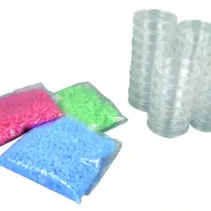 Tre Delvis fusionssæt-poser i pink, grøn og blå ved siden af to stabler petriskåle i klar plast.