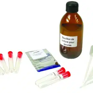 Et Mikrobiologisk initieringssæt - Gær med reagensglas, pipetter og en lille pakke står på en hvid flade.