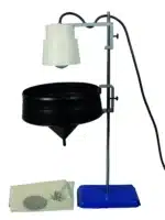 Et Berlèse og Baermann-apparat med en lampe på et stativ over en tragt, blå bund og filtermaterialer på siden.