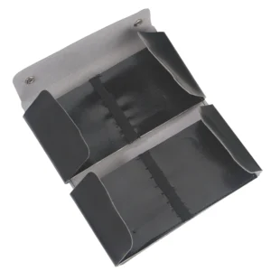 Et sort og gråt Tomt etui til 10-instrument i læder med to lommer og trykknapper på den øverste kant.