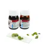 Ekstraktions- og krystalliseringssæt til parietin (lav): To brune flasker med fare-mærker, hvide låg, glasplade og grønne plantedele.