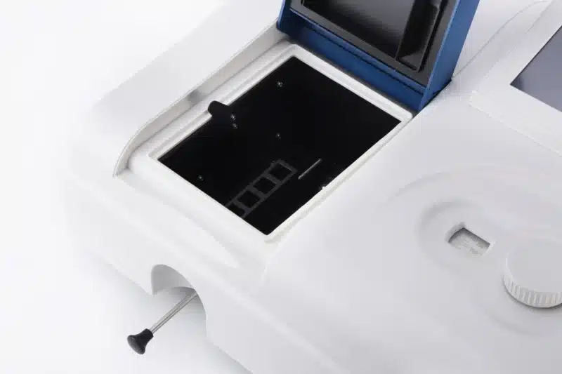 Nærbillede af et åbent rum på Kompakt UV-Vis spektrofotometer, der viser åbninger til prøveholdere.