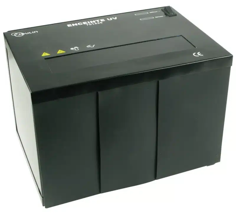 UV-lampe i-kabinettet er en sort, rektangulær enhed med mærkede knapper og advarselssymboler på toppen.