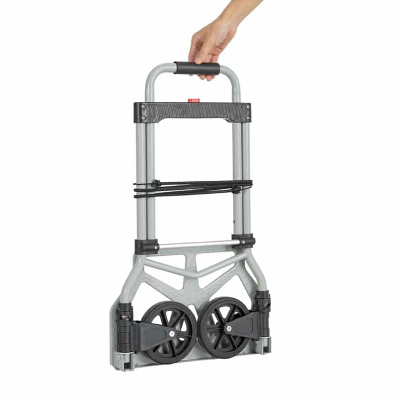 En hånd holder en sammenfoldet Sækkevogn, en letvægts metalvogn med to sorte hjul og et sort håndtag.